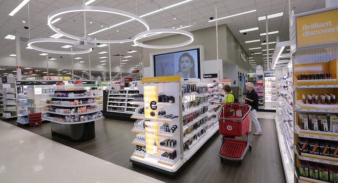 In this May 30, 2018, photo, shoppers look through the updated cosmetic department at a Target store in San Antonio. Success of specialty chains like Sephora and Ulta has pushed discounters like Walmart and Target as well as drugstores like CVS to revamp their cosmetics areas with more open spaces, brighter lighting and more attractive fixtures. (AP Photo/Eric Gay)