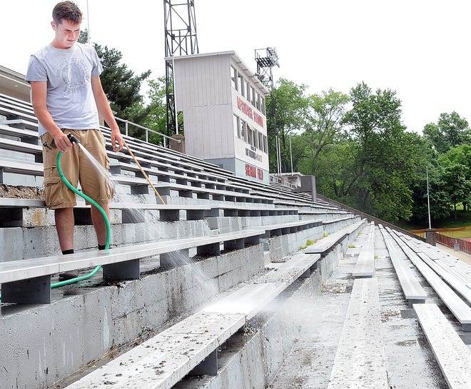 Eli Green blasts the bleachers clean at Muskingum University's McConagha Stadium Wednesday. There has been plenty of warm days this week but there have also been several periods of rain.