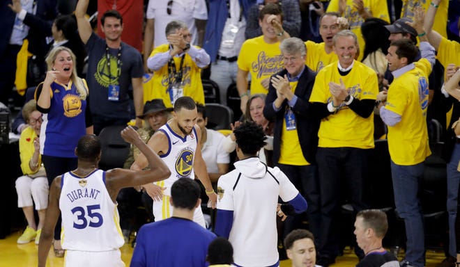 Golden State Warriors guard Stephen Curry (30) is congratulated by teammates after scoring against the Cleveland Cavaliers during the first half of Game 1 of basketball's NBA Finals in Oakland, Calif., Thursday, May 31, 2018. (AP Photo/Marcio Jose Sanchez)