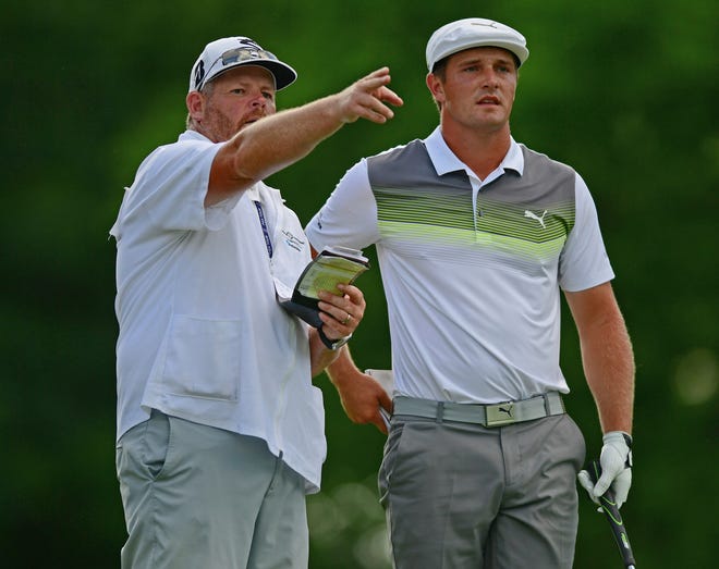 Bryson DeChambeau (right) listens to his caddie, Tim Tucker, along the 18th fairway during Saturday's third round of the Memorial. [David Dermer/The Associated Press]