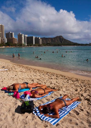 Sunbathers enjoy Waikiki Beach in Honolulu with Diamond Head in the background. Hawaii's Kilauea volcano has captivated people around the world by shooting lava high into the sky and sending rivers of molten rock pouring down hillsides into the ocean over the past month, but it's only one of many volcanoes in the islands. [Marco Garcia / AP file]