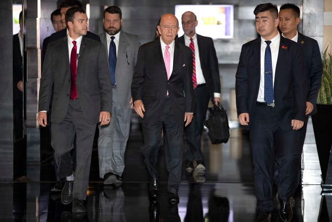 U.S. Commerce Secretary Wilbur Ross, center, leaves his hotel in Beijing, Saturday, June 2, 2018. U.S. Commerce Secretary Ross has arrived in Beijing for talks on China's promise to buy more American goods after Washington revived tensions by renewing its threat of tariff hikes on Chinese high-tech exports. (AP Photo/Mark Schiefelbein)