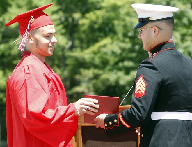US Marine Corps Sgt. Robert Pascasio, right, who graduated from Milford High in 2012, presents a diploma to his brother Justin Sunday. [Daily News and Wicked Local Photo/Marshall Wolff]
