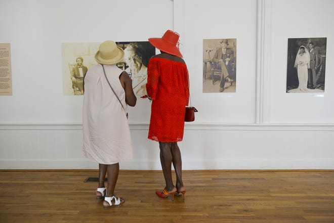 Velmon Johnson, left, and her sister, Corine Ackerson-Jones, peruse the gallery of photos from the W.W Law Collection at The Beach Institute African-American Cultural Center on Sunday.The images, all black and white, date from the 1870s through the 1990s, and document the lives of people of Savannah and elsewhere. [Will Peebles/Savannahnow.com]