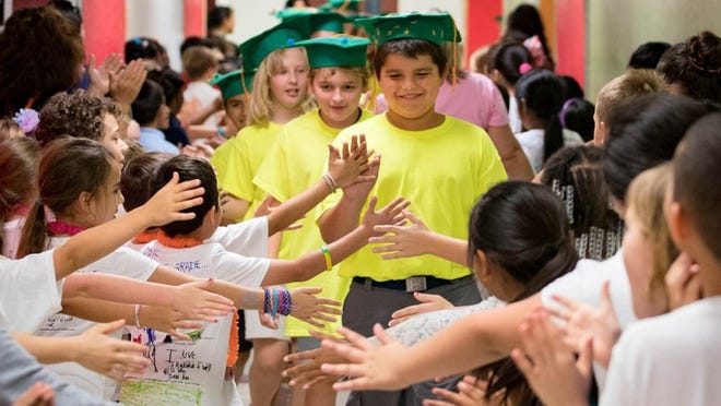 Palm Beach Public School fifth-grader John Cimballa of Palm Beach leads his 66 classmates on their final walk though the halls on the last day of school on June 1, 2018. (Allen Eyestone / Daily News)