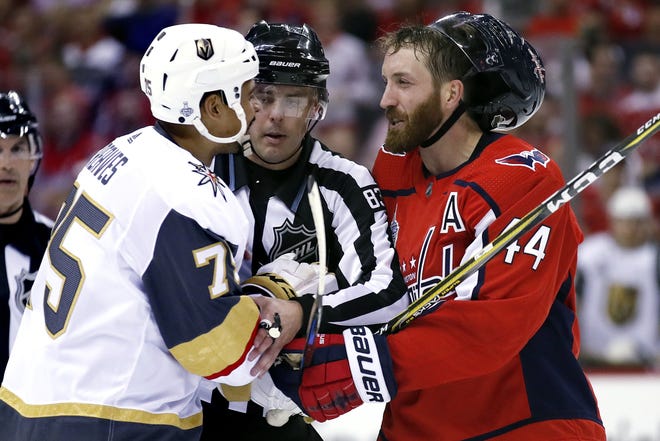 Linesman Matt MacPherson, center, steps in to separate Vegas Golden Knights forward Ryan Reaves, left, and Washington Capitals defenseman Brooks Orpik during the third period in Game 3 of the Stanley Cup Finals on Saturday. [AP PHOTO/ALEX BRANDON]