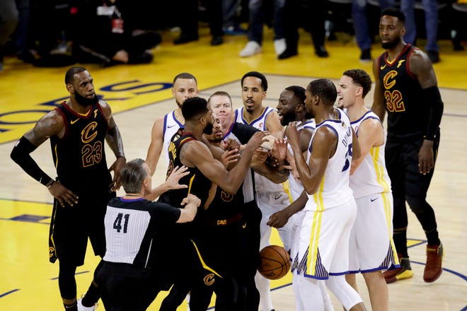 An official tries to separate Cleveland Cavaliers center Tristan Thompson and Golden State Warriors forward Draymond Green during overtime of Game 1 of basketball's NBA Finals in Oakland, Calif., Thursday, May 31, 2018. The Warriors won 124-114. (AP Photo/Marcio Jose Sanchez)