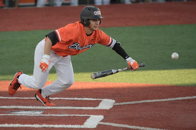 This photo taken June 4, 2018, shows Oregon State's Nick Madrigal putting down a bunt against Yale during an NCAA college baseball regional tournament game in Corvallis, Ore. His slight physical build makes him look anything but one of the best college players in the country, but he's very much in the mold of similarly vertically challenged big league All-Stars Jose Altuve and Dustin Pedroia. Madrigal is considered by many to be the best overall hitter in the draft. (Mark Ylen/Albany Democrat-Herald via AP)