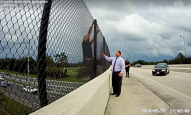 This image from an Ocala Police Department officer's body camera shows Detective Joshua Fried talking with a man who was threatening to jump from the Southwest 43rd Street Road overpass on Interstate 75 last week. [From video/courtesy of OPD]