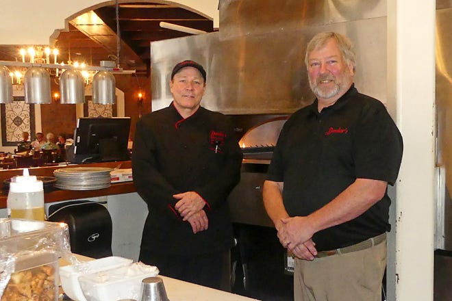 Chef Danny Connolly, left, and owner Dennis Demshar pose for a photo in front of the open kitchen pizza oven at Demshar's. The restaurant in The Villages offers casual and upscale dining. [LINDA FLOREA / CORRESPONDENT]