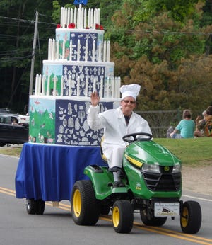 A birthday cake honoring Madbury’s 250th Anniversary decorated with artwork from students at Moharimet Elementary School is driven by Garret Ahlstrom, its “chef," in the Madbury Day Parade on June 2. [Courtesy photo]