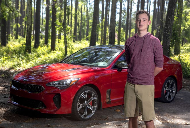 Landen Lewis shows off his 2018 Kia Stinger at Devils Millhopper Geological State Park. [PHOTO BY ALAN YOUNGBLOOD]