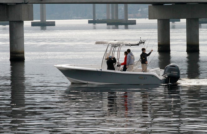 Fishermen cruise past the Front Street Bridge in New Bern. Fishing and boating remains a popular sport and activity for inland waters during the winter months. [Gray Whitley / Sun Journal Staff]
