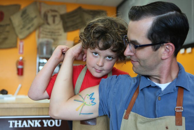 Mike and Sarah Caven named their chocolate shop for a “Sanity” figure (tattoo on Mike’s arm) that their son, Adrian, left, drew when he was younger. [Kelly Lyon/The Register-Guard] - registerguard.com