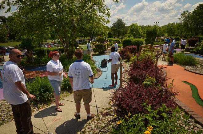 Participants in the Putts Fore Butz annual mini golf tournament compete in last year's fundraiser. The event this year will take place on Sunday. [COURTESY OF NICOLE BUTZ]