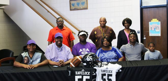 Havelock's Will Spottsville (center in purple shirt) is joined by his family as he signed his National Letter of Intent to play football at ASA College in Miami. [CONTRIBUTED PHOTO]