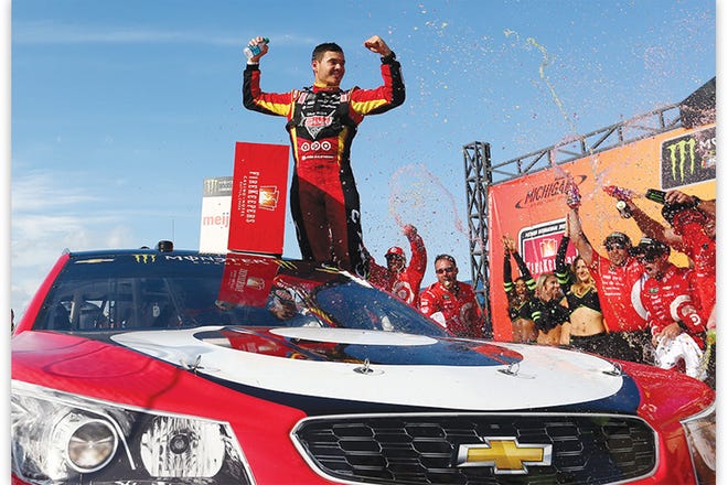 Kyle Larson celebrates in Victory Lane after winning the Monster Energy NASCAR Cup Series FireKeepers Casino 400 at Michigan International Speedway on June 18, 2017, in Brooklyn, Mich.