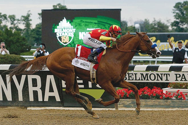 Justify, with jockey Mike Smith up, crosses the finish line to win the 150th running of the Belmont Stakes on Saturday in Elmont, N.Y.