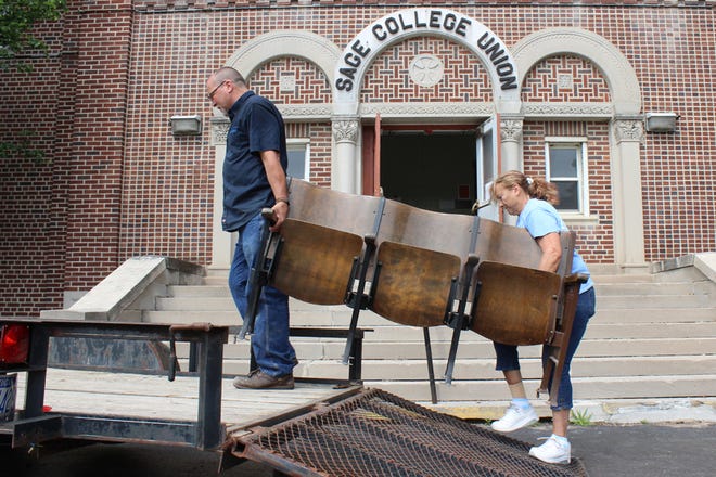 Randy Lighthall and Renee Bracey remove theater seats from Sage Union Hall Friday at Siena Heights University. The 95-year-old hall is set to be razed in the coming weeks.