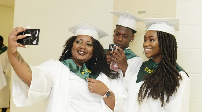 From left, India Bright, Richie Cobb and Mary Anne Ogbaugo capture a moment before the start of their graduation ceremony Saturday at Kinston High School. [Janet S. Carter / The Free Press]