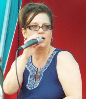 Christine Miller, vocalist for the Mood Rings, performs Friday during the Rockin at the Caboose concert in downtown Alliance