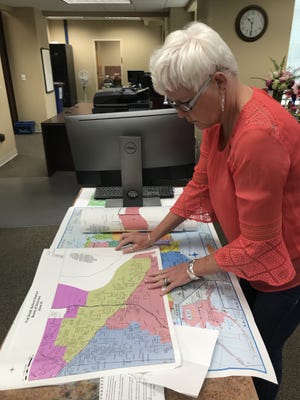 Darlene Neumeier, office manager for the Sebastian County Clerk, looks over county maps defining school zones. A voter's recent inquiry uncovered the county clerk's designation of Greenwood School District is different from the city's. [JOHN LOVETT/TIMES RECORD]