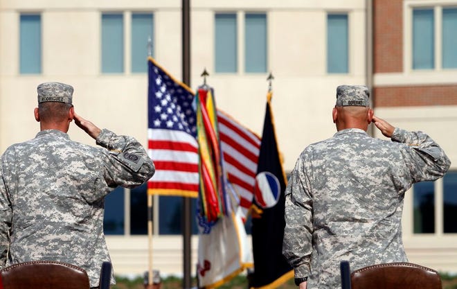 In this Sept. 12, 2011 file photo, generals salute during an installation ceremony at the U.S Army Forces Command at Fort Bragg, N.C., one the Army's three major command headquarters. The Army is scouting large cities in 2018 to find a home for a fourth command headquarters, one that would be near experts in technology and innovation who can help focus on the Army's future. The site is expected to be announced by the end of June 2018. (AP Photo/Jim R. Bounds, File)