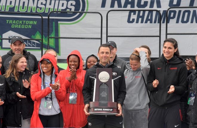 Members of the Georgia women's team and coach Petros Kyprianou pose with the national runner-up trophy during the NCAA Track and Field championships at Hayward Field in Eugene, Ore. (Photo by Kirby Lee-Image of Sport)