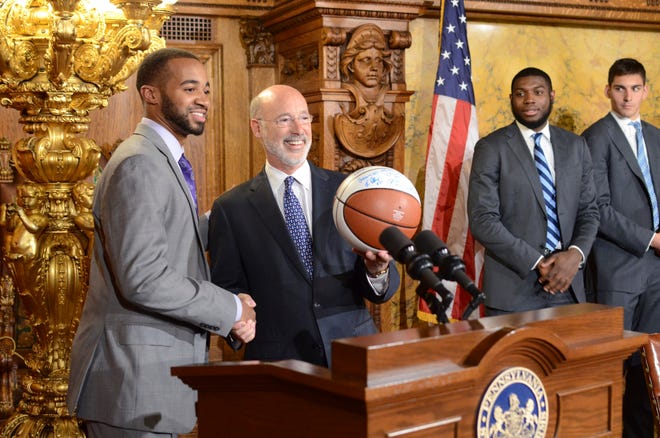 Gov. Tom Wolf shows off an autographed basketball presented to him by Phil Booth and three other members of Villanova's championship-winning men's basketball team Tuesday. [MARC LEVY/THE ASSOCIATED PRESS]