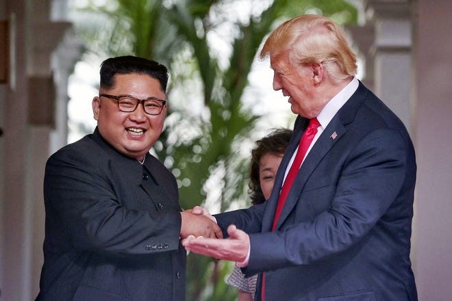 U. S. President Donald Trump shakes hands with North Korea leader Kim Jong Un at the Capella resort on Sentosa Island Tuesday in Singapore. [KEVIN LIM/THE STRAITS TIMES/ASSOCIATED PRESS]