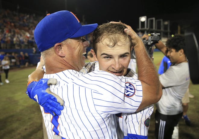 Florida head coach Kevin O'Sullivan celebrates with Austin Langworthy after he hit a walk-off home run against Auburn in an NCAA Super Regional on Monday in Gainesville. [MATT STAMEY/THE ASSOCIATED PRESS]