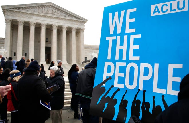 FILE - In this Jan. 10, 2018, file photo, people rally outside of the Supreme Court in opposition to Ohio's voter roll purges in Washington. The Supreme Court is allowing Ohio to clean up its voting rolls by targeting people who haven't cast ballots in a while. The justices are rejecting, by a 5-4 vote on June 11, 2018, arguments that the practice violates a federal law that was intended to increase the ranks of registered voters.(AP Photo/Jacquelyn Martin, File)