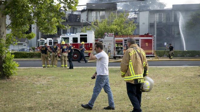 Mike Dempsey watches his home burn at the Mission James Place Apartments on Tuesday. JAY JANNER / AMERICAN-STATESMAN
