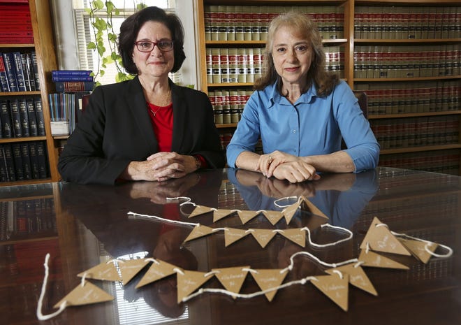 LtoR Julianne Taaffe and Kathy Moon at the law office of their attorney Fred Gittes in Columbus on June 8, 2018. They are holding a small banner Kathy has made with the names of colleagues who they say were impacted by her Ohio State department's practices that the federal EEOC found discriminated against older workers. [Eric Albrecht/Dispatch]