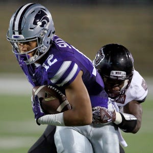 FILE - In this Sept. 24, 2016, file photo, Kansas State wide receiver Corey Sutton (12) is tackled by Missouri State cornerback Matt Rush during the first half of an NCAA college football game in Manhattan, Kan. College athletes will no longer need permission from their coach or school to transfer and receive financial aid from another school after the NCAA Division I Council passed a proposal that has been in the works for months. Standoffs between athletes and coaches over transfers have often led to embarrassing results for schools standing in the way of player who wishes to leave. Last spring at Kansas State, reserve receiver Corey Sutton said he was blocked him from transferring to 35 schools by coach Bill Snyder before the school finally relented after public pressure. (AP Photo/Orlin Wagner, FIle)