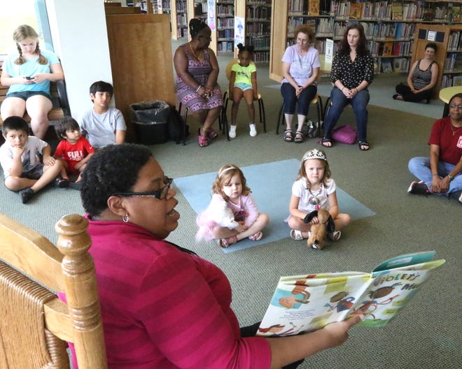 Janine Miller, Windsor Library branch manager, bottom left, reads 'Violet's Music' to children and parents Tuesday, June 12, 2018, during the Terrific Tuesday program, Music & Movement Storytime at the branch. The Main Library will host Wild West Wednesday at 2 p.m., as well as Super Saturday Doggie Dance at 10:30 a.m. Saturday. [JAMIE MITCHELL/TIMES RECORD]
