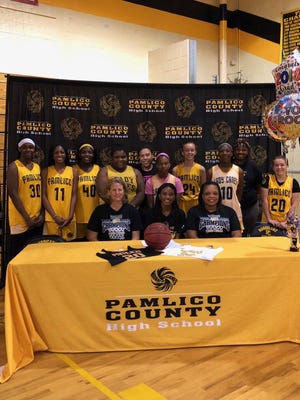 Pamlico County's Chaniya Dudley (front, center) signs her National Letter of Intent to play basketball at Lenoir Community College. Dudley is joined by coaches April Rose (front, left) and Naomi Wilson (front, right) along with her Hurricane teammates. [CONTRIBUTED PHOTO]