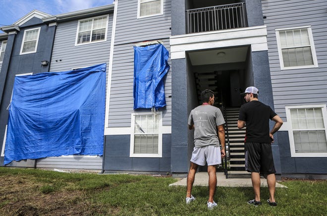 Residents at Westbrook Apartments get a first look at their building where a gunman held four children hostage before taking their life and his own, Tuesday, June 12, 2018, in Orlando, Fla. The standoff began when an Orlando police officer was shot responding to a domestic violence call. (Jacob Langston/Orlando Sentinel via AP)