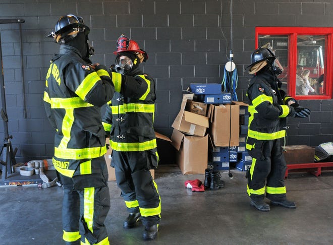 Firefighters try on new gear at Mount Dora Fire Department on Thursday. The gear is designed to protect them against cancer-causing contaminants they are prone to while on the job. [Tom Benitez/Correspondent]