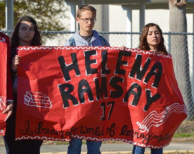 Leesburg High School students hold a sign to honor Helena Ramsay, who was one of the 17 people killed at Marjory Stoneman Douglas, during a walkout on Wednesday, March 14, 2018, in Leesburg. [Whitney Lehnecker/Daily Commercial]