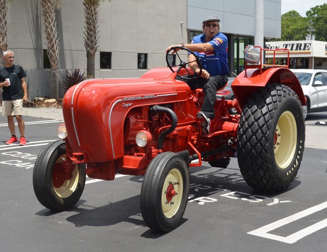 Brumos Collection director Don Leatherwood enjoys his cigar while wheeling a 1957 Porsche 308 Super diesel tractor out of the Porsche Club of America show, held June 9 at Porsche Jacksonville. [DAN SCANLAN/FLORIDA TIMES-UNION]