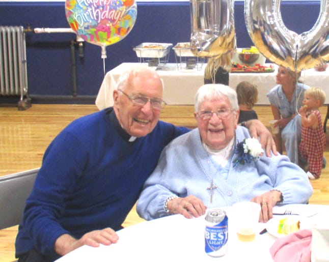 Fr. Tom Acker, S.J., helps Mary Denny of Suffield celebrate her 108th birthday.
