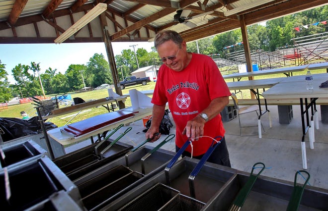 Larry Canipe prepares the grill for the first night of Rodeo Polkville, which runs today and Saturday. [Brittany Randolph/The star]