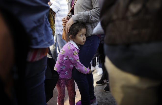 INicole Hernandez, of the Mexican state of Guerrero, holds on to her mother as they wait with other families to request political asylum in the United States, across the border in Tijuana, Mexico, on Wednesday. The family has waited for about a week in this Mexican border city, hoping for a chance to escape widespread violence in their home state. [AP Photo / Gregory Bull]
