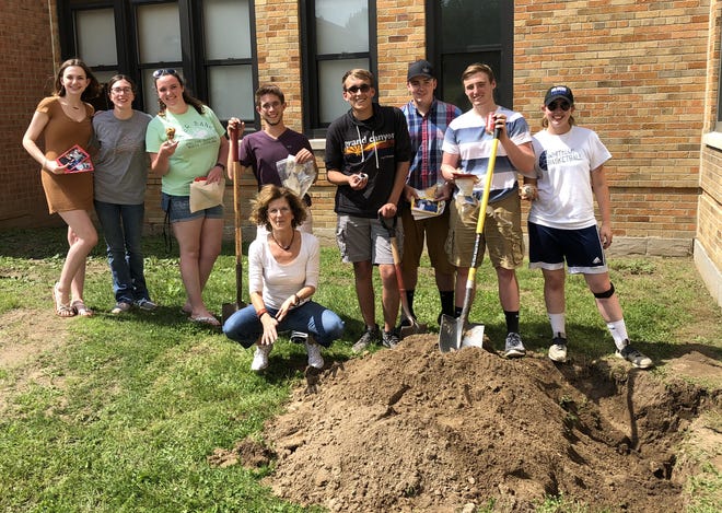 Graduating Marcus Whitman seniors pose with the personal trinkets they buried 11 years ago in a time capsule when they were in the first-grade class of Lisa Orlando, seated. From left, are: Chloe Gagner, Amanda Hopper, Sydney Davis, Dominick Morey, James Johnston, Logan Dennis, Preston Smith and Katrina (Stevens) Meyer. Their first-grade class photo follows.

[PHOTO PROVIDED/MARCUS WHITMAN SCHOOLS]