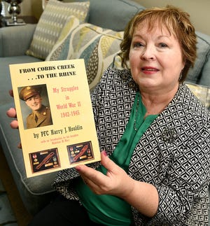 Madeline Marr holds the book of her father's days fighting in Europe during WWII. Marr recently had his memoirs published. [ART GENTILE / STAFF PHOTOJOURNALIST]