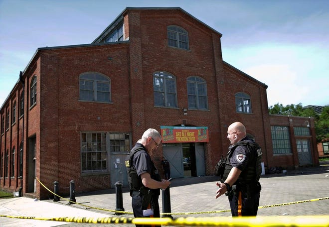 Police stand guard outside the warehouse building where the Art All Night Trenton 2018 festival that was the scene of a shooting that resulted in numerous injuries and at least one death Sunday in Trenton, N.J.