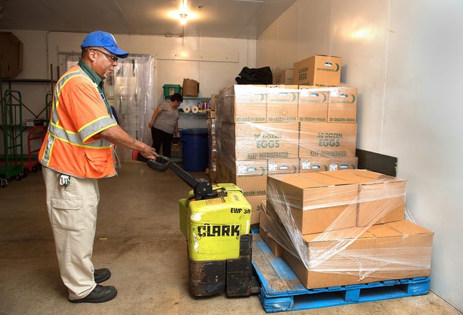 George Burrows, a truck driver from Philabundance, delivers a pallet of boxed lunches as well as produce to a refrigerated storage room at the Bucks County Central Warehouse in Doylestown Township. [BILL FRASER / STAFF PHOTOJOURNALIST]