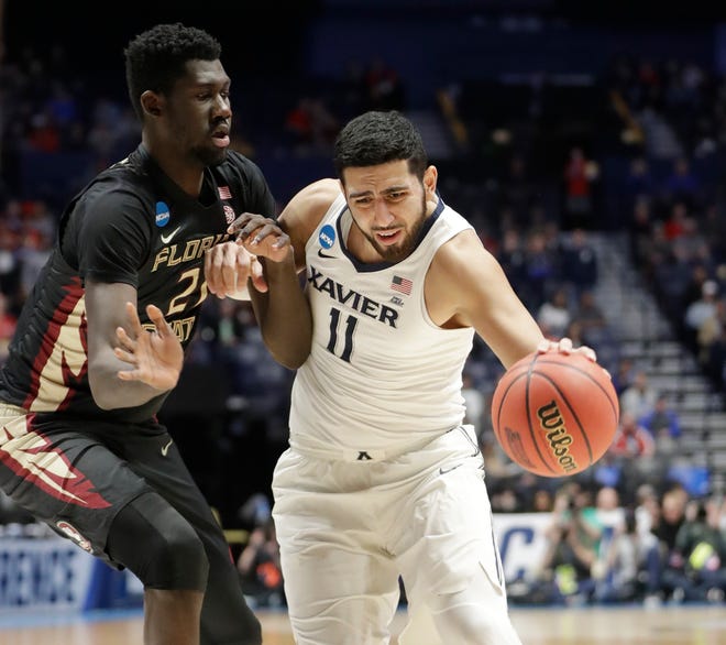 Xavier forward Kerem Kanter (11) goes around Florida State center Christ Koumadje during the second round of the NCAA Tournament on March 18 in Nashville. [AP PHOTO]