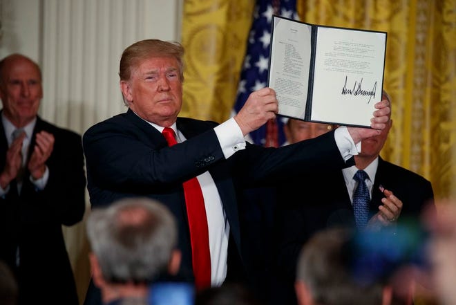 President Donald Trump shows off a "Space Policy Directive" after signing it during a meeting of the National Space Council in the East Room of the White House, Monday, June 18, 2018, in Washington. (AP Photo/Evan Vucci)